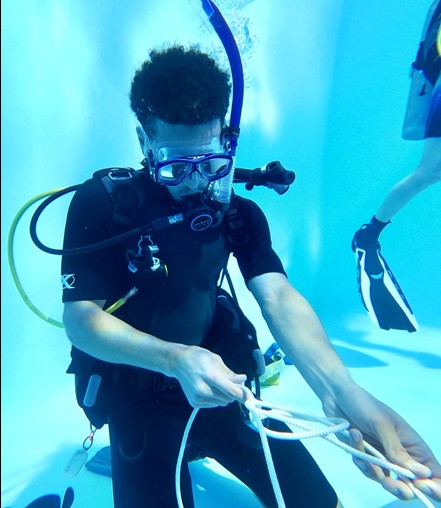 Scientific-Diver-in-Training and 2021 scholarship recipient Donoven Baughman practicing underwater knot tying at Morcom Aquatics Center. Students in FSU's Scientific Diving course practice skills like these that will prepare them to safely and effectively conduct underwater research.