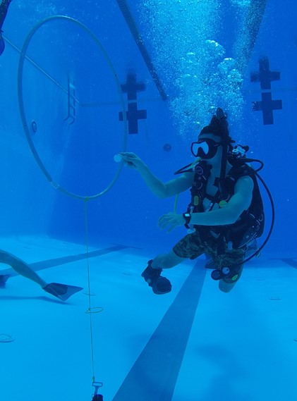 Scientific-Diver-in-Training and 2021 scholarship recipient Adin Nahoa Domen practiices completing complex tasks (balancing an egg on a spoon while swimming through a hoop) while regulating buoyancy underwater.